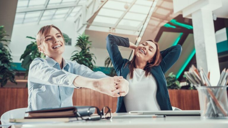 Two women exercising in office